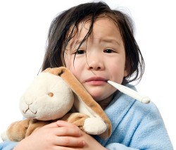 A young girl is sick and having her temperature taken.